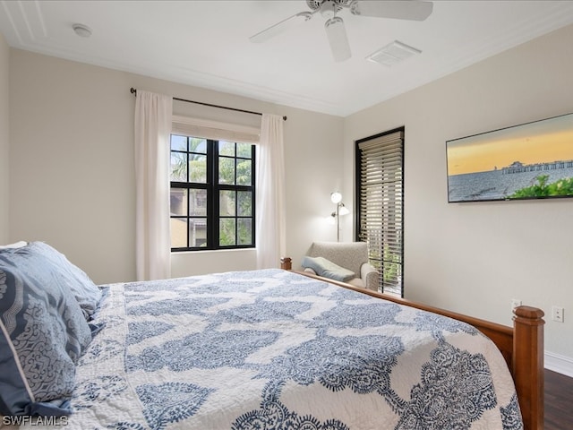 bedroom featuring hardwood / wood-style flooring, ornamental molding, and ceiling fan