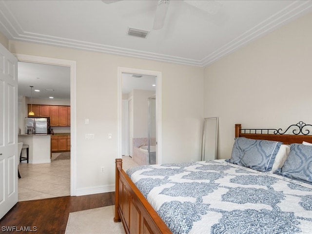 bedroom with stainless steel refrigerator with ice dispenser, ceiling fan, connected bathroom, and light tile floors