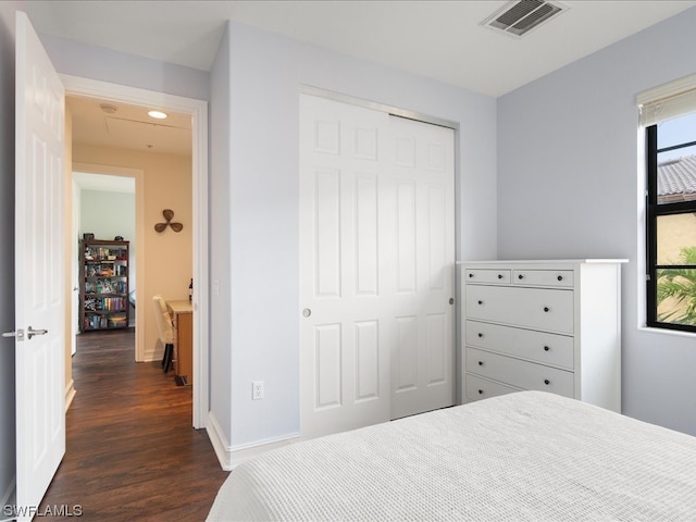 bedroom with a closet and dark wood-type flooring