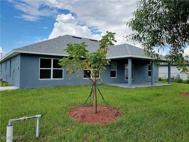 back of house featuring a patio and a yard