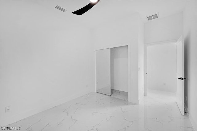 unfurnished bedroom with light tile flooring, a closet, and ceiling fan