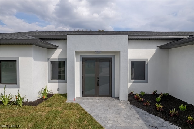 entrance to property with a yard and french doors