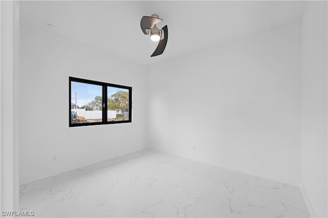 tiled spare room featuring ceiling fan