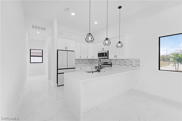 kitchen featuring stainless steel appliances, light tile floors, decorative light fixtures, tasteful backsplash, and white cabinetry