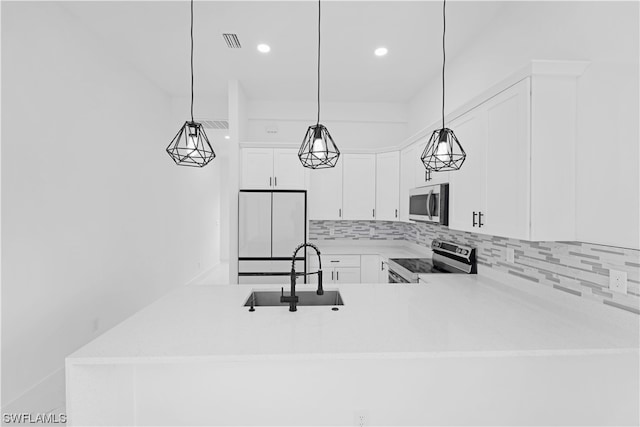 kitchen featuring appliances with stainless steel finishes, white cabinetry, sink, and pendant lighting