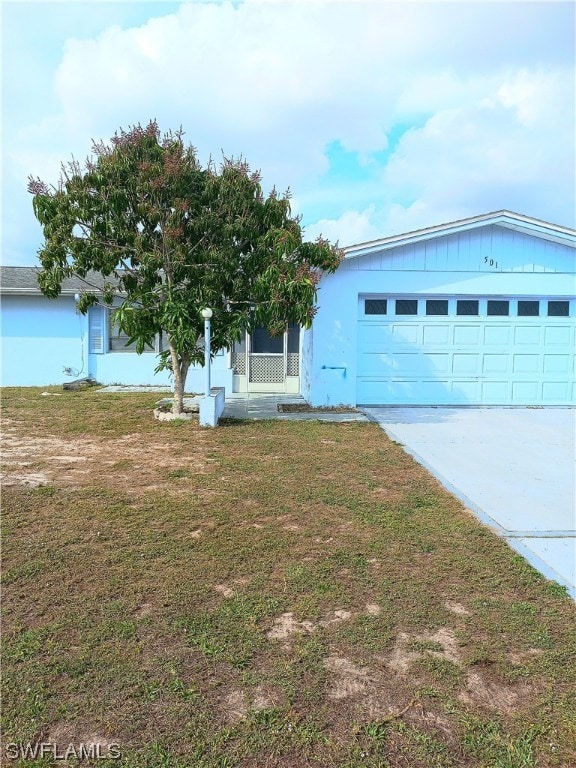 view of front of home with a front yard and a garage