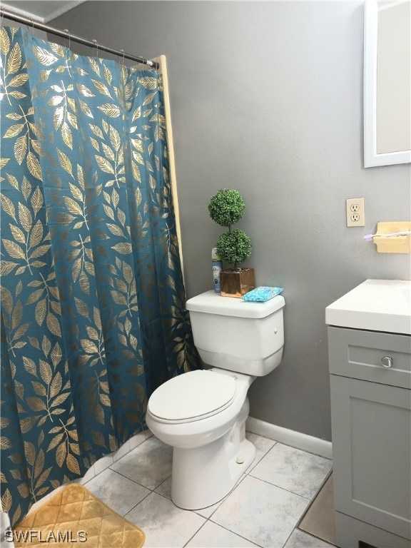 bathroom featuring toilet, tile floors, and vanity