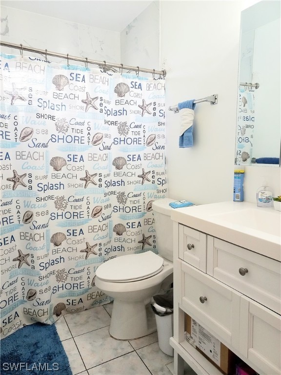 bathroom featuring toilet, tile flooring, and vanity