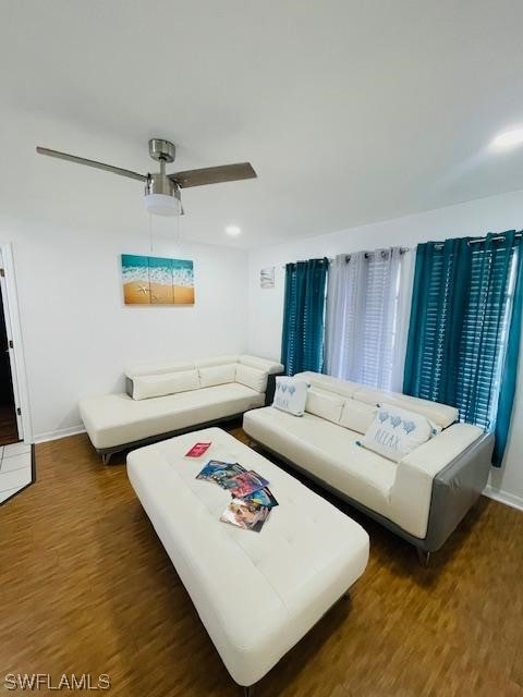 living room with ceiling fan and dark hardwood / wood-style floors