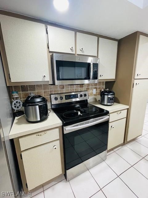 kitchen featuring light tile floors, appliances with stainless steel finishes, and tasteful backsplash