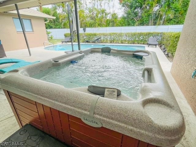 view of pool with a hot tub