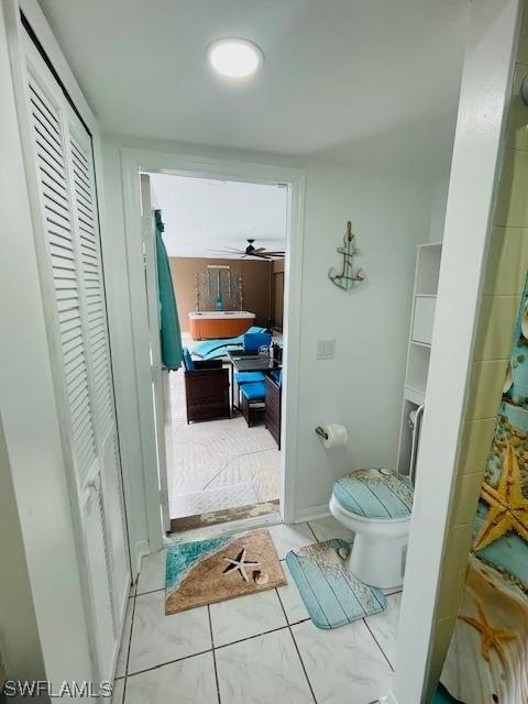 bathroom with toilet, ceiling fan, and tile flooring