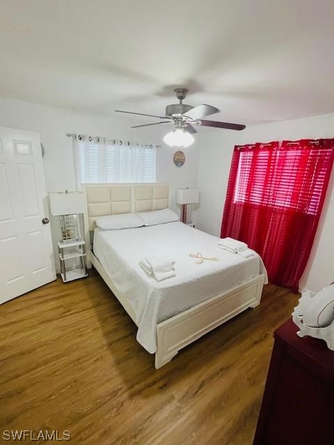 bedroom with dark hardwood / wood-style floors and ceiling fan