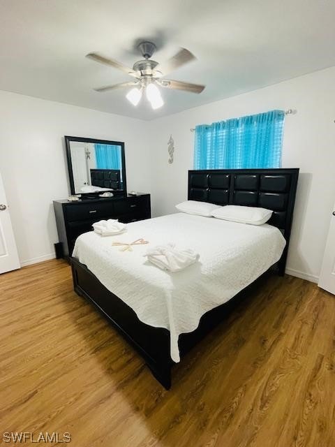 bedroom with ceiling fan and hardwood / wood-style flooring