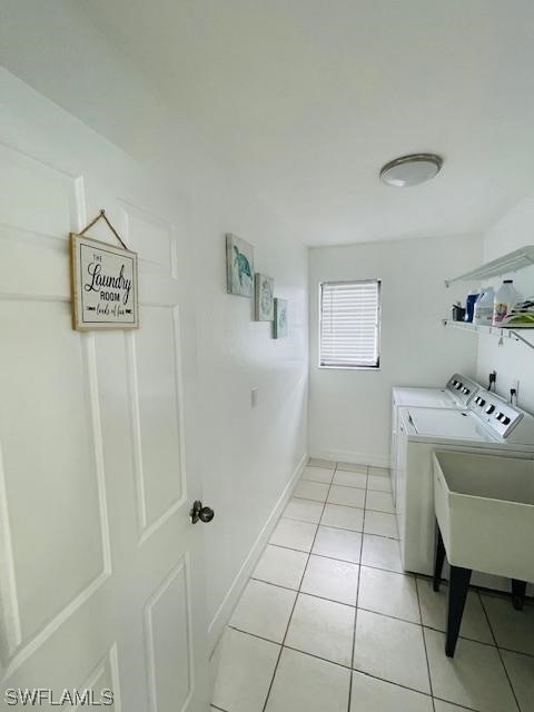 laundry area featuring light tile floors and washer and clothes dryer