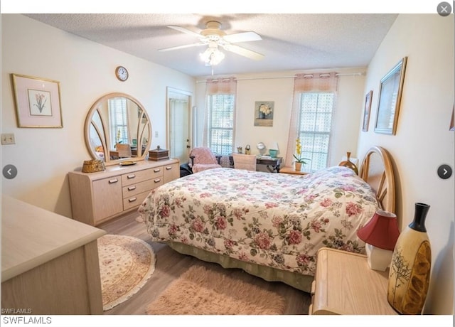 bedroom featuring a textured ceiling, ceiling fan, and light wood-type flooring