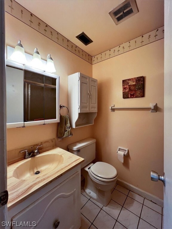 bathroom featuring tile patterned floors, vanity, and toilet