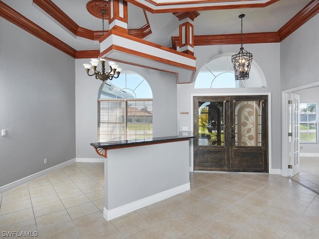 entrance foyer featuring crown molding, an inviting chandelier, and light tile floors