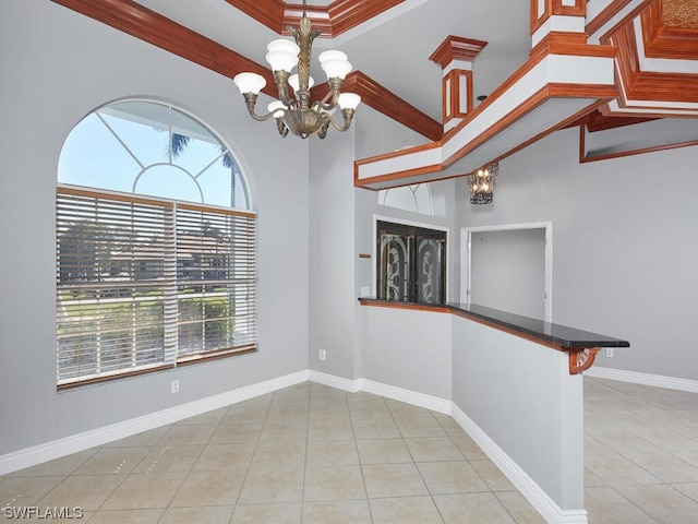 spare room featuring a chandelier, crown molding, and light tile flooring