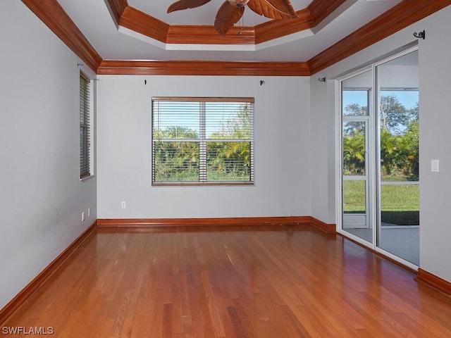 spare room featuring plenty of natural light, dark wood-type flooring, ceiling fan, and crown molding