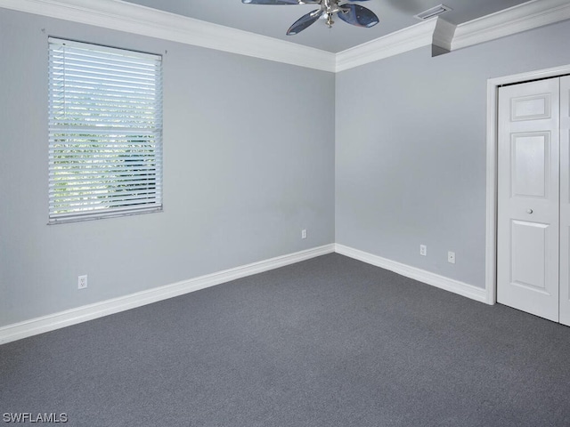 spare room with dark carpet, crown molding, and ceiling fan