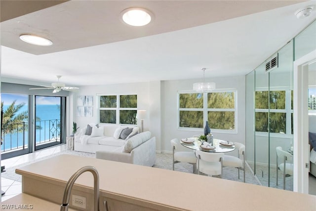 living room with ceiling fan, visible vents, and baseboards