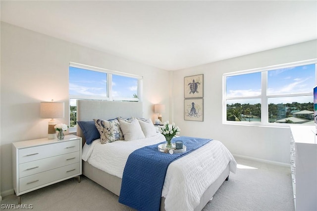 bedroom with baseboards and light colored carpet