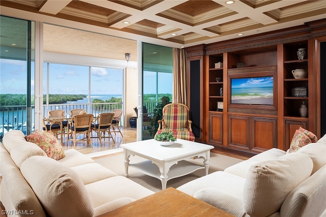 living room with beam ceiling, ornamental molding, coffered ceiling, and a water view