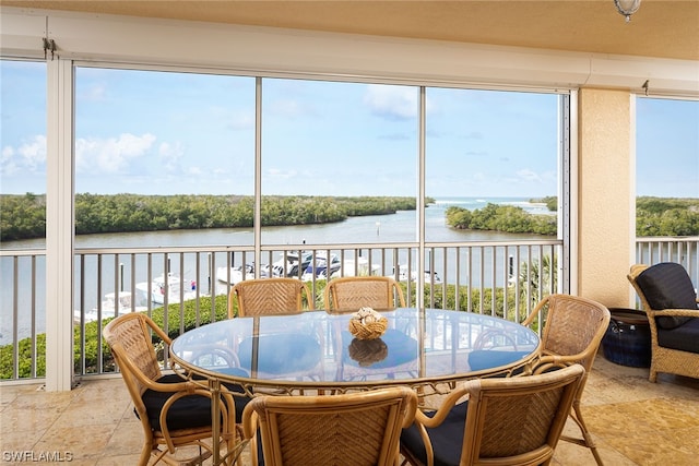 sunroom / solarium featuring a water view and a healthy amount of sunlight