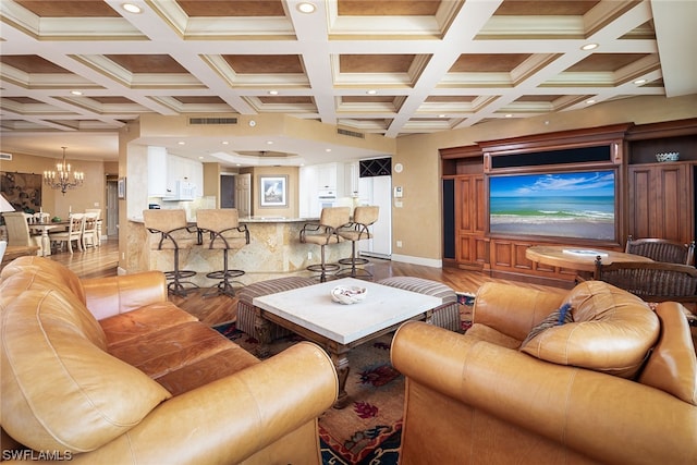 living room with hardwood / wood-style flooring, a chandelier, ornamental molding, beamed ceiling, and coffered ceiling