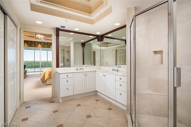 bathroom featuring a raised ceiling, ceiling fan, ornamental molding, vanity, and an enclosed shower