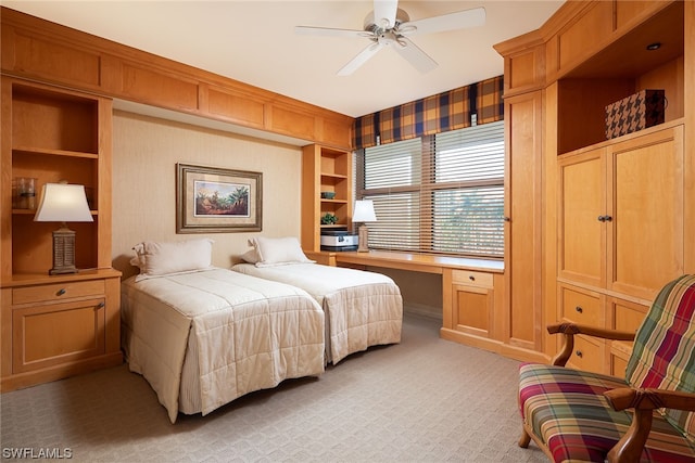 bedroom featuring built in desk, ceiling fan, and carpet floors