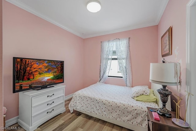 bedroom featuring ornamental molding and light hardwood / wood-style flooring