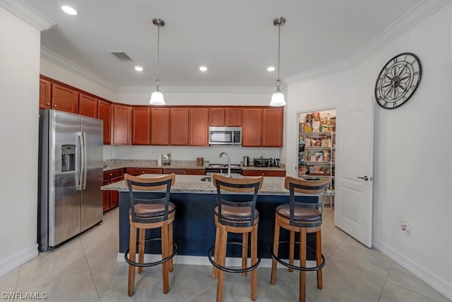 kitchen with a center island with sink, stainless steel appliances, hanging light fixtures, and light stone countertops