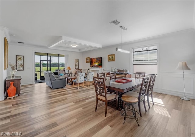 dining space featuring ornamental molding and light wood-type flooring