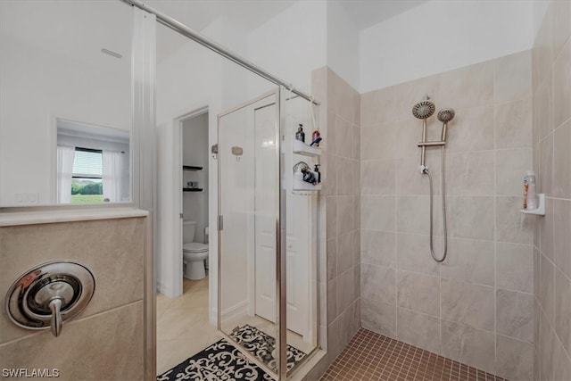 bathroom with a tile shower, tile floors, and toilet