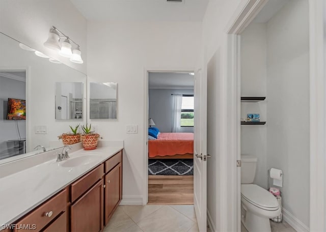 bathroom featuring toilet, tile floors, vanity, and crown molding