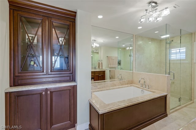 bathroom featuring shower with separate bathtub, vanity, and tile patterned floors