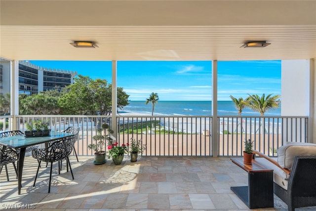 view of patio featuring a balcony, a view of the beach, and a water view