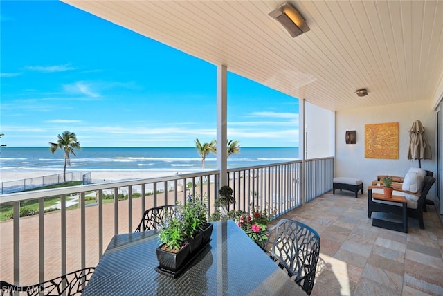 balcony featuring a beach view and a water view