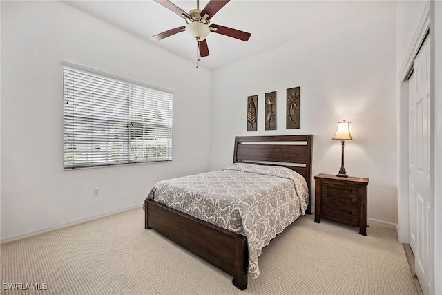 carpeted bedroom with ceiling fan and a closet