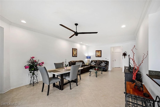 dining space with crown molding, ceiling fan, and light tile patterned flooring