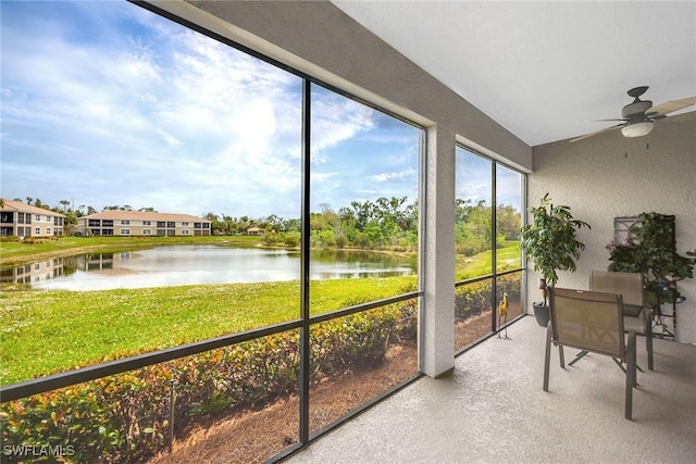 sunroom with a water view and ceiling fan