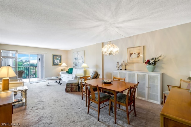 carpeted dining room with a textured ceiling and a chandelier