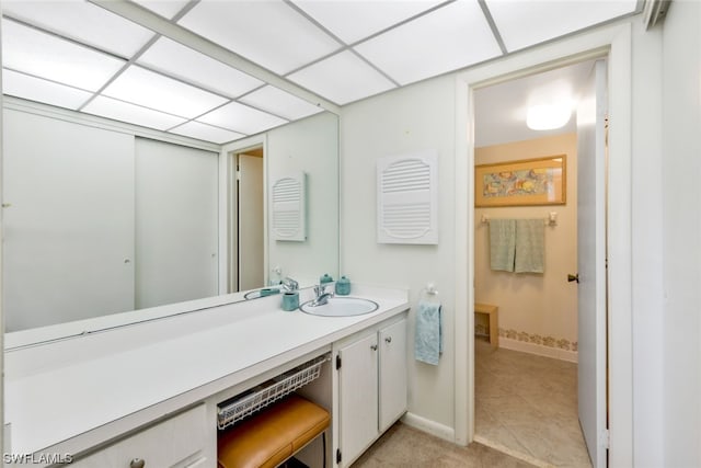 bathroom with vanity, a drop ceiling, and tile patterned floors