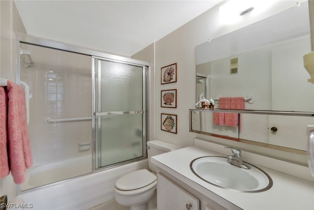 full bathroom with vanity, enclosed tub / shower combo, and toilet