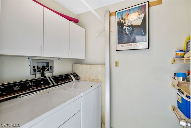 laundry area with washing machine and dryer and cabinets