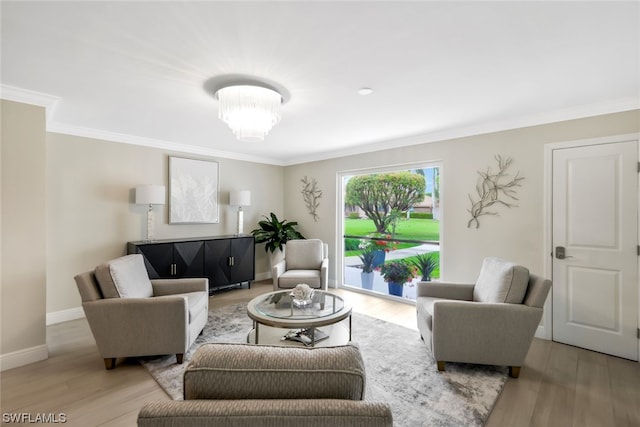 living room featuring light hardwood / wood-style flooring, ornamental molding, and a notable chandelier