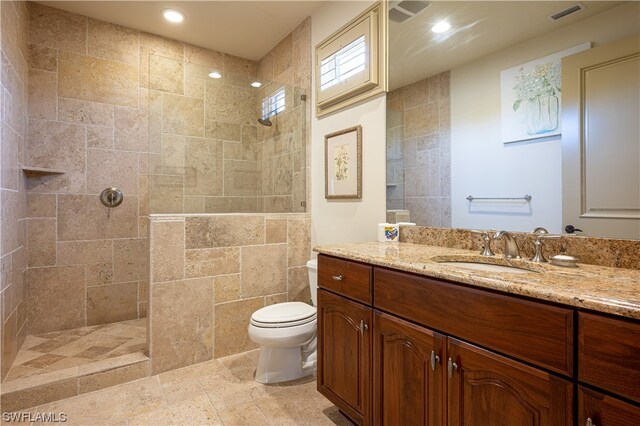 bathroom with tile walls, toilet, tiled shower, and tile flooring