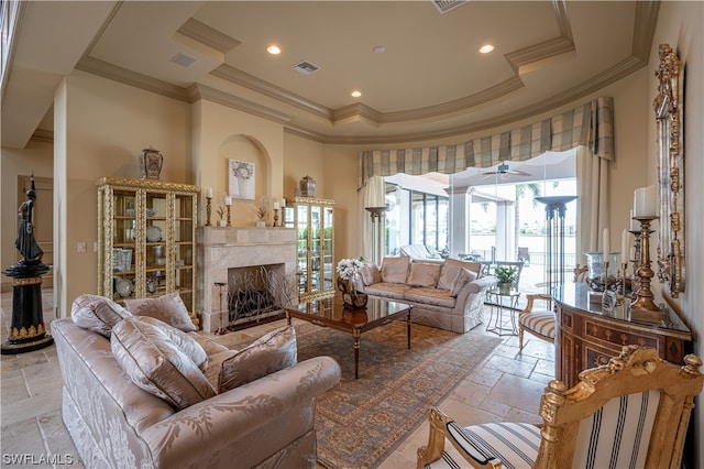 tiled living room with a raised ceiling, ornamental molding, a fireplace, and a towering ceiling